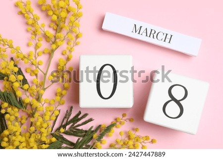 International Women's day - 8th of March. Wooden block calendar and beautiful flowers on pink background, flat lay