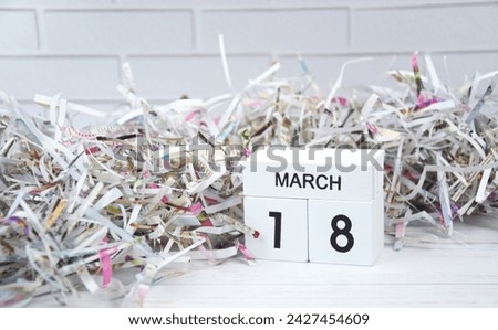 Wooden calendar with the date March 18 with paper and plastic. World Recycling Day.