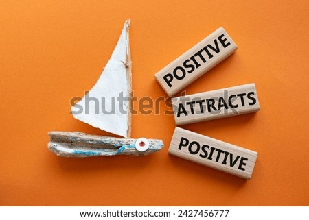 Positive attracts Positive symbol. Wooden blocks with words Positive attracts Positive. Beautiful orange background with boat. Business concept. Copy space.