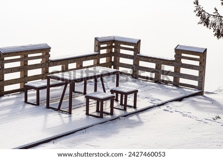 Winter frozen lake copy space image park bench covered in snow