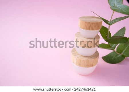 Natural cosmetics concept, cream jars over soft pink background