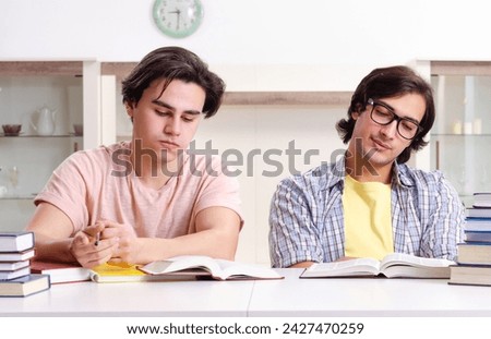 Two male students preparing for exams at home Royalty-Free Stock Photo #2427470259