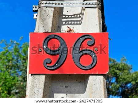 Street sign number 96 on a concrete pole