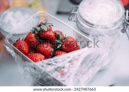 plastic box with strawberries on white background