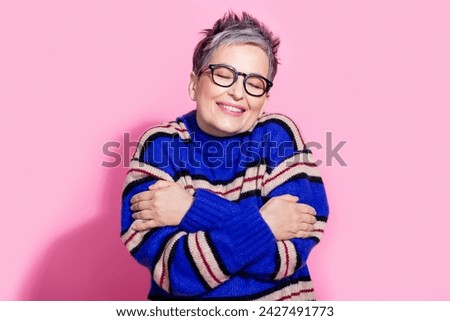 Photo portrait of attractive pensioner woman hugging self enjoy warmth wear trendy blue striped clothes isolated on pink color background Royalty-Free Stock Photo #2427491773