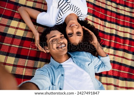 High angle view portrait of two peaceful idyllic people laying blanket cuddle take selfie record video