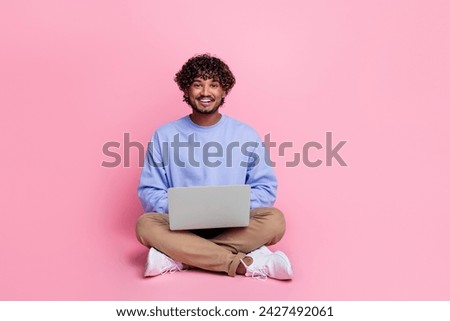 Full body photo of attractive young man sit floor work netbook smm manager wear trendy blue clothes isolated on pink color background