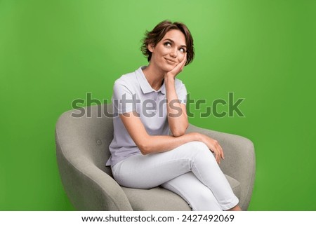 Photo of dreamy cute lady wear grey t-shirt hand arm cheekbone cheek looking empty space isolated green color background