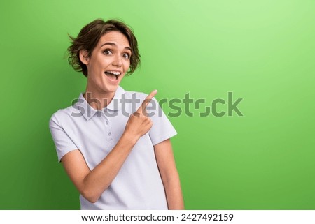 Photo attractive young woman astonished recommend subscribe social media channel where posts promo codes isolated on green color background