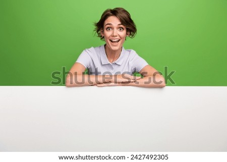 Photo of lovely pretty cheerful girl wear stylish clothes stand demonstrate empty space news poster isolated on green color background