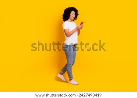 Full length photo of pretty sweet woman wear white t-shirt texting apple iphone samsung modern device isolated yellow color background