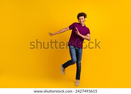 Photo of funky cheerful man wear trendy violet clothes dance freestyle listen loud music isolated on yellow color background