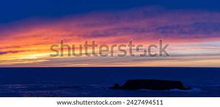 brilliant panorama sunset on Oregon coast with Otter Rock in foreground