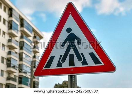 Urban Pedestrian Crossing Sign - Safety and Caution in City Traffic, Cityscape Background with a Pedestrian Crossing Sign - Road Rules and Tips Royalty-Free Stock Photo #2427508939