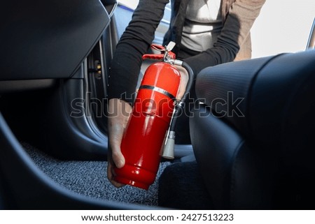 Installing a car fire extinguisher inside a car Royalty-Free Stock Photo #2427513223