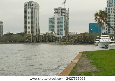 View horizontal west over seawall at Vinoy Park Marina in St. Petersburg, Florida looking towards downtown Saint Petersburg, Florida . With docked boats and palm trees on right side. City skyline.
