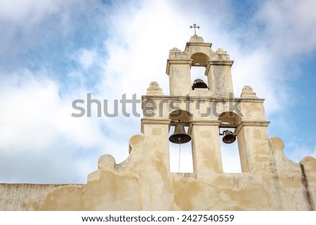 Traditional marble bell tower of the old Mission San Juan located at the San Antonio Mission Historical Park in San Antonio Texas. Picture is taken on a partly cloudy day