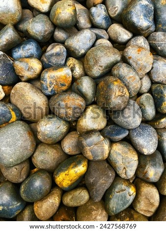 Many colorful pebble in nature. Beautiful pebble stone backdrop for websites, presentation and other publications.