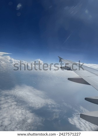 A picture of clouds and an airplane wings