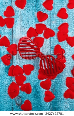 Valentine's Day concept with heart shaped glasses, and a lot of hearts on a blue wooden background. 