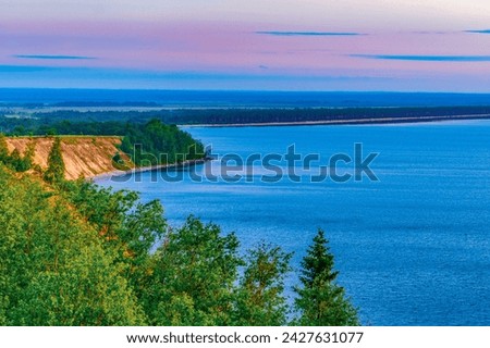 Seascape - the shore of Lake Onega in selective focus against the background of clouds at sunset.Karelian landscape.Concept of traveling around the Russian North.ecology, ecotourism.Forest lake. 