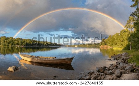 Rainy weather in a lake in Sweden, the sky is cloudy, sunlight comes out of the clouds, and a rainbow extends from the beginning of the picture to the end in the form of an arc.