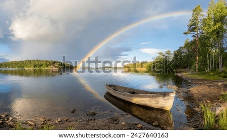 Rainy weather in a lake in Sweden, the sky is cloudy, sunlight comes out of the clouds, and a rainbow extends from the beginning of the picture to the end in the form of an arc.