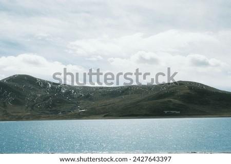 a lake with mountains in the background and a cloudy sky