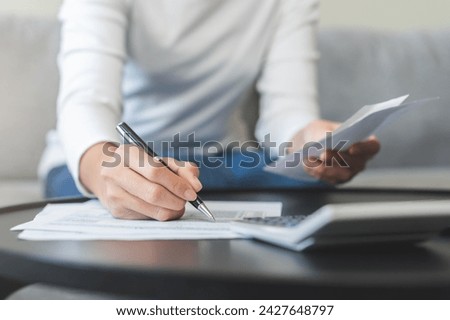 Deduction planning concept, woman hand writing report account from bill calculating balance prepare planning filling 1040 tax form business individual income for pay money form personal tax reduction.