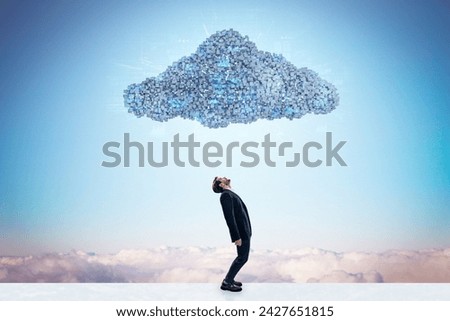 Side view of businessman standing under abstract digital cloud with programming language on bright sky background. Digital storage, database, network and technology concept