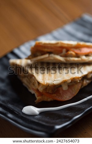 Roll tortilla with grilled chicken fillet on wooden cutting boar