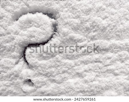 Question mark written in the snow. The cold frosty texture of the snow and the question mark. Background, place for text, copy space