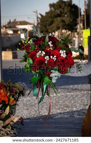 A vibrant bouquet of red roses elegantly tied to a pole, offering a beautiful display of romance and love.