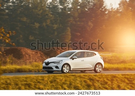 Isolated modern vehicle on the highway during sunset. Enjoying the Summer Trip with a Luxury car on a Sunny Highway Royalty-Free Stock Photo #2427673513
