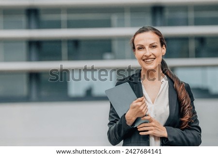 business woman with tablet smiling outdoors