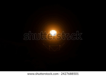 Warm light emerges from the lights of a cafe with a dark black background
