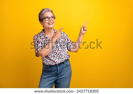 Photo of pretty retired female point look empty space dressed stylish leopard print outfit isolated on yellow color background