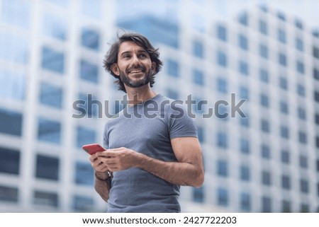 View of a young man with smartphone at daytime with city view landscape in the background. High quality photo.