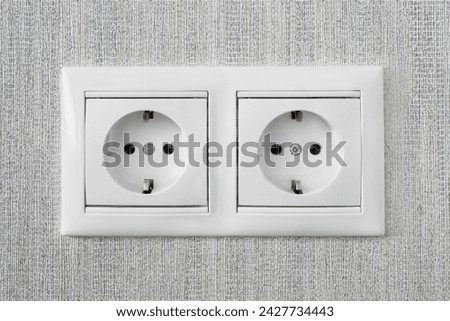 Two white domestic european standard power sockets on a wall closeup
