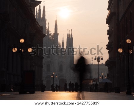 view of Milan city in the morning sunrise with motion blurred people walking in piazza Duomo, Milano, Italy long exposure photography
