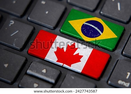 Canada and Brazil flags on computer keyboard. Relationship between two countries. Royalty-Free Stock Photo #2427743587