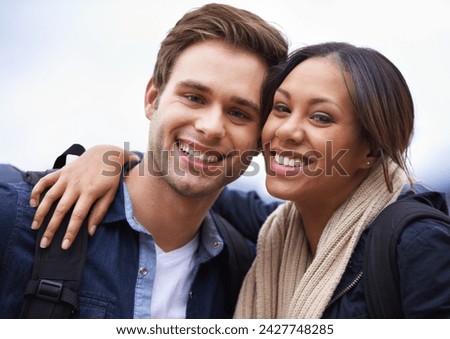 Couple, portrait and outdoor for hiking, adventure and travel in winter, grey or cloudy sky in smile and backpack. Face, happy or interracial people with hug in profile picture or selfie for trekking