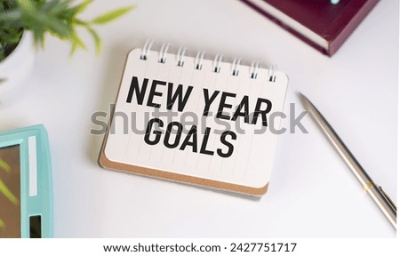 New Year goals, resolution or action plan concept. Notebook on table with calendar, plant and stationery. Flat lay (top view) notepad for input copy or text on turquoise background.