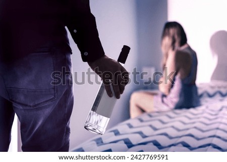 Alcohol and domestic violence. Drunk partner and husband with addiction. Wife in fear. Violent addict spouse. Couple fight. Problem in family home. Physical abuse victim. Angry aggressive alcoholic. Royalty-Free Stock Photo #2427769591