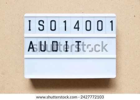 Lightbox with word ISO 14001 audit on wood background