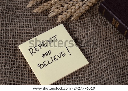 Repent and believe, handwritten verse note placed on sackcloth with wheat and holy bible book. Biblical concept of repentance, Christian growth, change, faith and belief in God Jesus Christ.