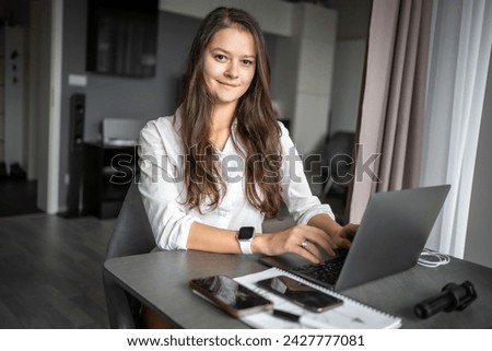Portrait of smiling young business woman with laptop in home workplace, home office, home studying or teaching concept. High quality photo