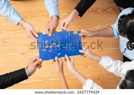 Top view multiethnic business people holding jigsaw pieces and merge them together as effective solution solving teamwork, shared vision and common goal combining diverse talent. Habiliment Royalty-Free Stock Photo #2427779439