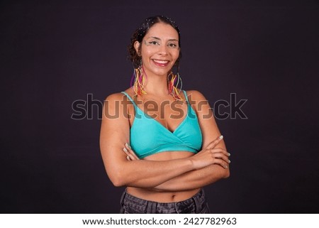 Beautiful woman dressed for carnival night smiling at the camera with her arms crossed