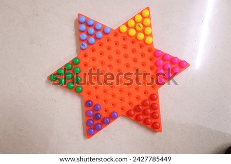 Chinese checkers with all multi colour coins on board isolated in white backdrop